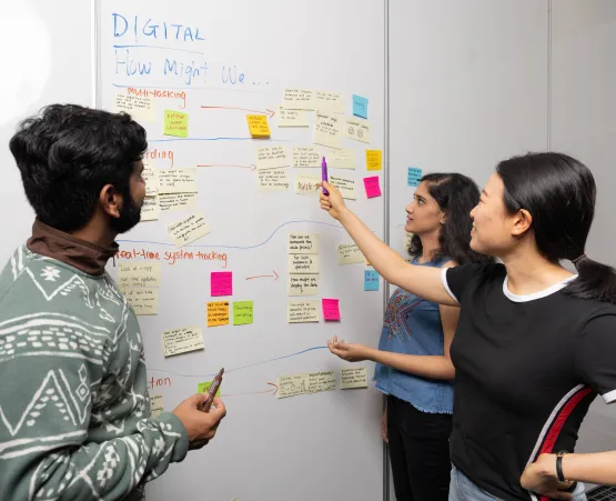 Students gathered around white board with sticky notes