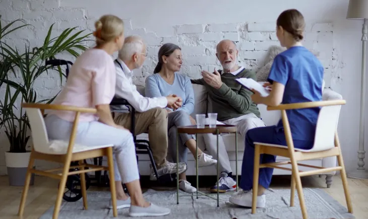 Two nurses talking to a senior couple